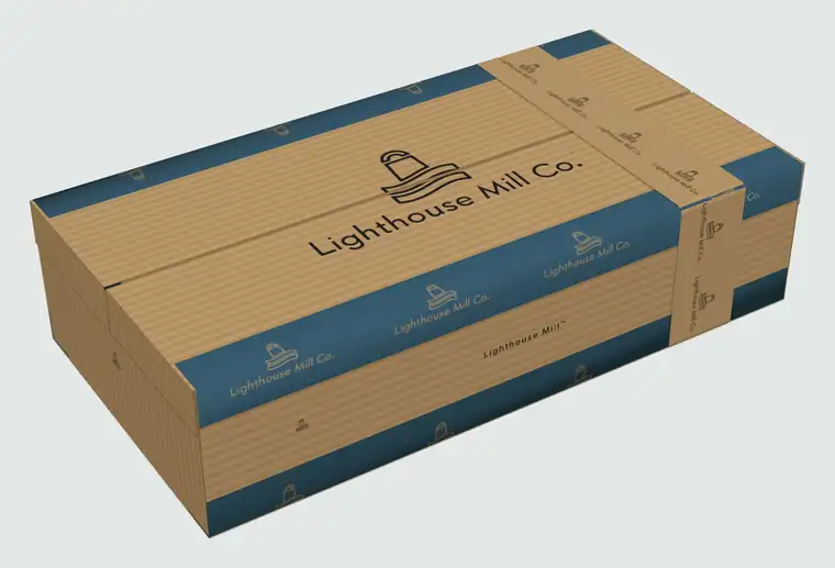 The double Lighthouse Mill box, closed, with a printed kraft band around it and the logo on the lid