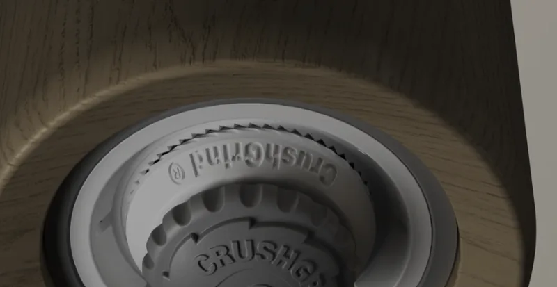 A close up render of the CrushGrind mechanism, with its serrated grinding ring, seated in a wooden mill